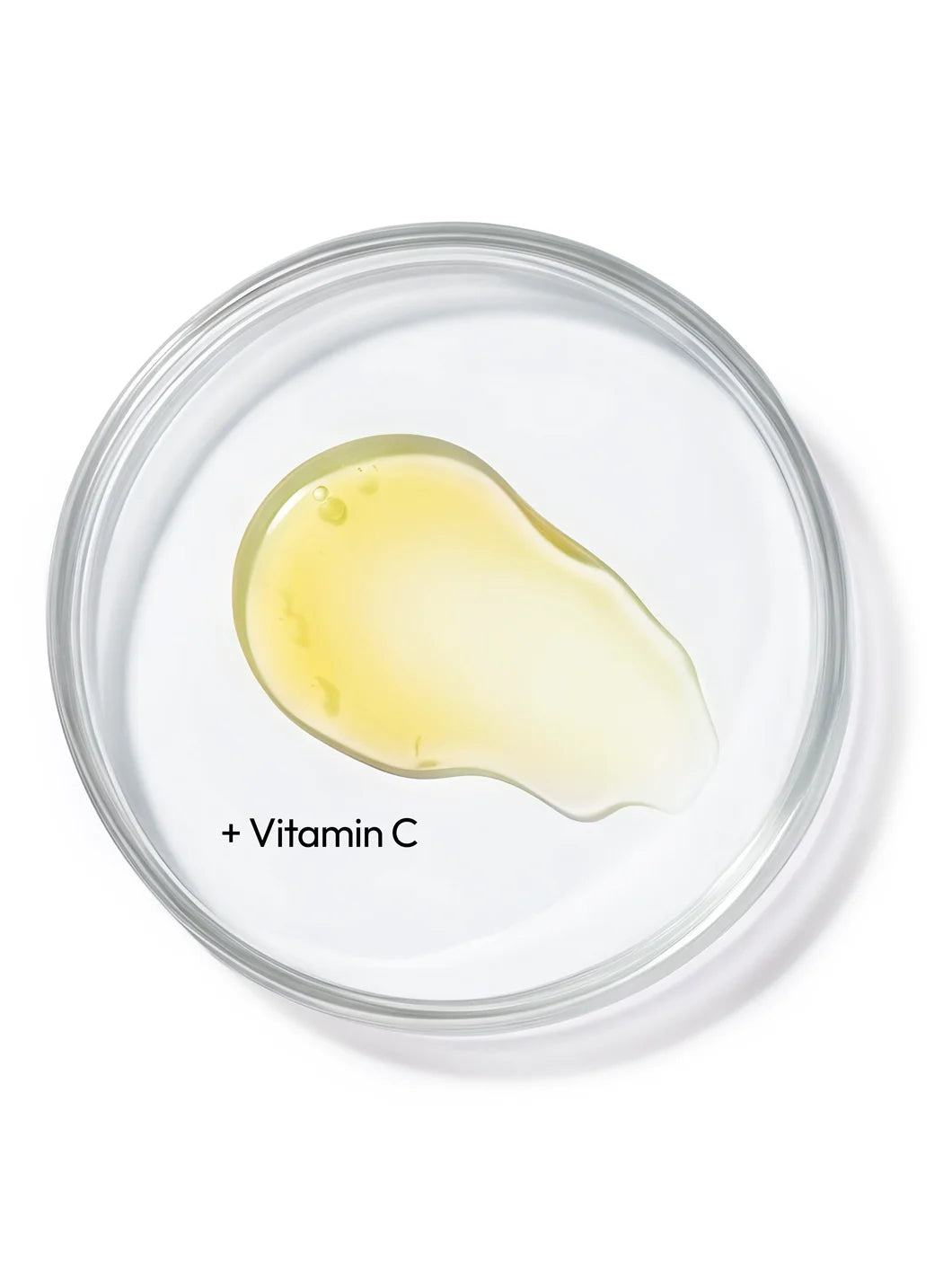 Top view of a light yellow liquid in a petri dish, illustrating vitamin C as a key brightening antioxidant ingredient used in Yelf Aging Bye Bye Vitamin C Serum