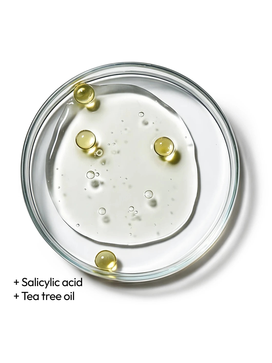 Top view of salicylic acid and tea tree oil droplets in a clear liquid texture in a petri dish, illustrating clarifying ingredients used in Yelf Spot Off Acne Cream
