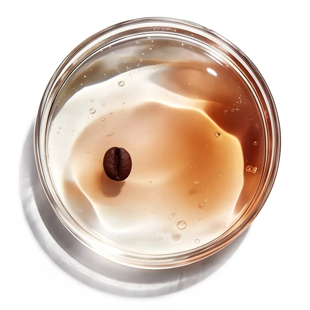 Yelf Viva el Boost Caffeine Gel shown with a coffee bean suspended in a warm-toned gel with small air bubbles in a petri dish, bright studio lighting, minimal skincare aesthetic